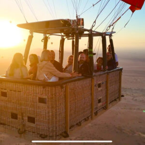 Passenger hot air balloon basket backlit by the rising sun above the countryside near Marrakech